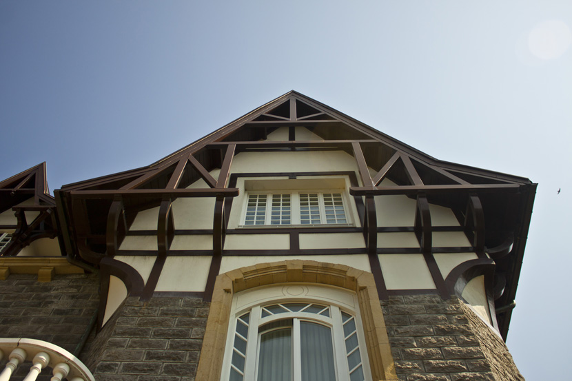 rehabilitación de fachada en gipuzkoa: vista del tejado rehabilitado y los elementos de madera de la fachada del edificio