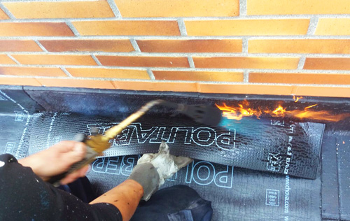 rehabilitación de fachada en Gipuzkoa: colocación de tela asfáltica en la cubierta